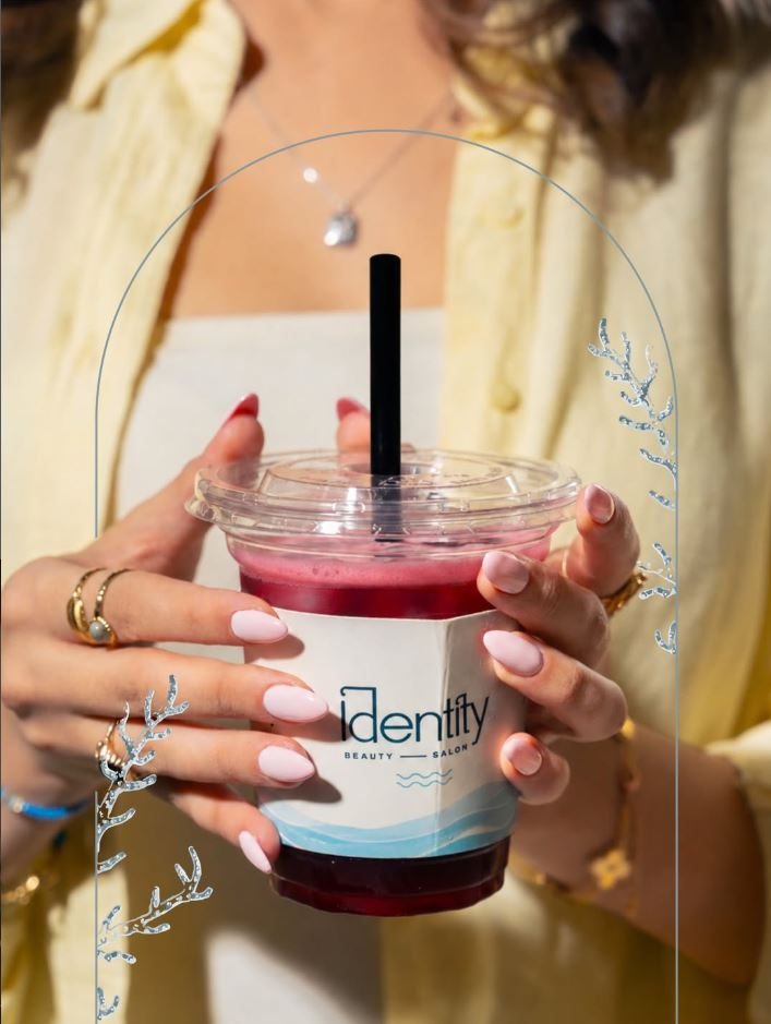 A client holding an Identity branded drink, fresh manicure
